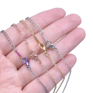 Detailed close-up of four stainless steel chains in gold, rose gold, silver and rainbow colors