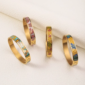 Macro shot of 18K gold plated enamel bangles featuring floral and butterfly motifs