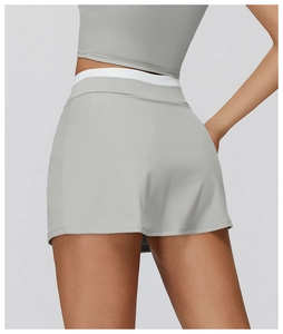 Dettaglio posteriore della gonna da tennis grigia a vita alta con bordo bianco a contrasto