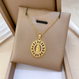 Gros plan d'un pendentif Vierge Marie doré avec zircons sur un fond de soie douce