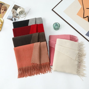 Close-up of neatly folded cashmere-style wool scarves with elegant fringe in six colors
