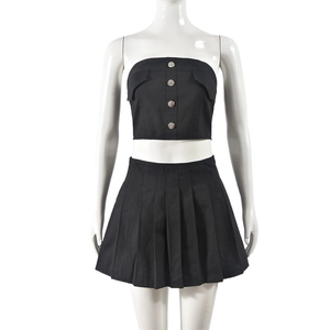Detailed view of black two-piece set featuring a tube top with buttons and pleated mini skirt