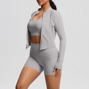 Détail d'un ensemble de yoga gris clair avec veste zippée, brassière et short à poche