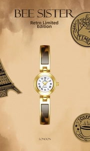 Close-up of vintage gold watch with white dial and tortoise shell pattern chain link
