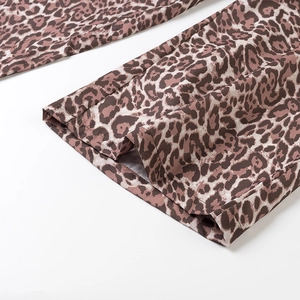 Dettaglio ravvicinato della trama leopardata e del drappeggio dei pantaloni larghi