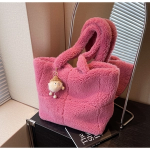 Detail der rosa Plüschtasche mit Fleece-Textur und niedlichem Plüschtier-Anhänger