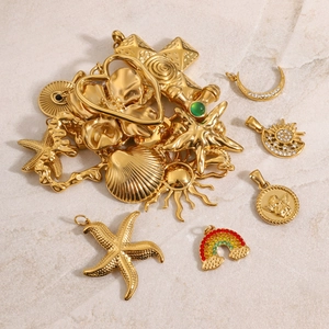 Flat lay detail van vintage 18k gouden roestvrijstalen bedels op marmeren achtergrond