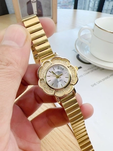 Detail of elegant gold petal-shaped watch case with diamond texture and sunray dial