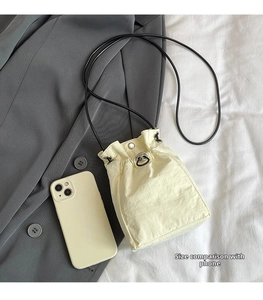 Mini beige bucket bag with drawstring and smartphone for size comparison scale