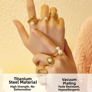 Close-up of stacked 18k gold plated titanium rings with pearls and fine rhinestones