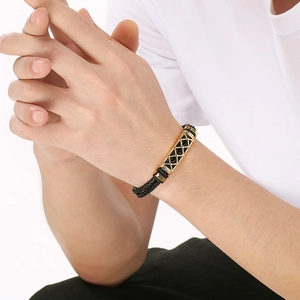 Close-up of men's double-braid black leather bracelet with a gold mesh pattern clasp