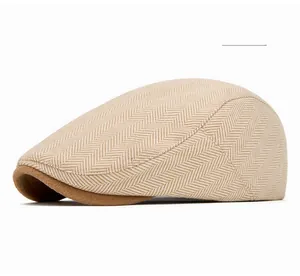 Detailed view of cream herringbone fabric texture and contrast brim on the flat cap