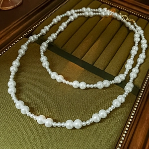 Détail d'un collier de perles élégant avec fermoir doré sur un coffret à bijoux rétro
