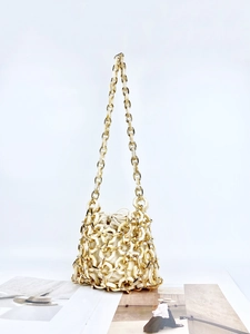 Chic cream acrylic woven drawstring bucket bag with elegant golden chain strap