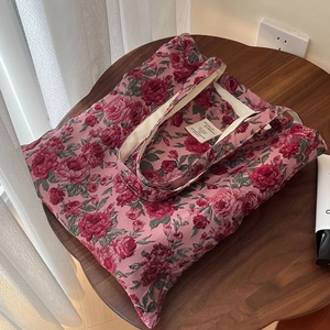 Sac cabas vintage en jacquard rose avec motif floral élégant sur table en bois