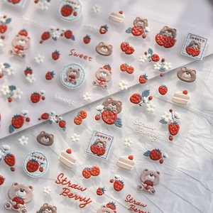Detail of embossed strawberry and bear nail art stickers with textured cream 3D patterns
