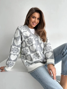 Détail du cardigan gris à col en V avec motifs de cœur et texture de maille blanche