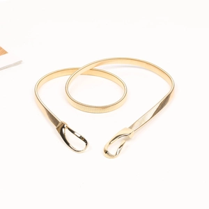 Close-up of golden spring metal waist belt featuring a polished hook buckle closure