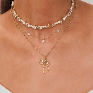 Three-layer gold bow necklace with pearls, clover charms, and zircons for women