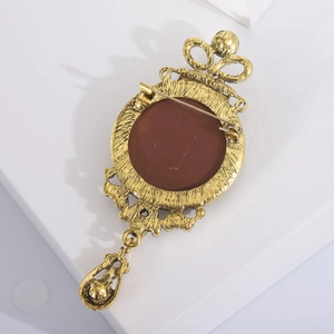Detailed back view of vintage gold crown brooch with safety pin fastener and pendant