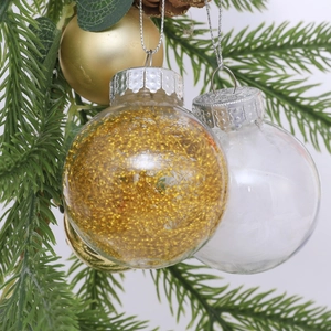Clear Christmas baubles with gold sequins and white feathers hanging on a tree branch