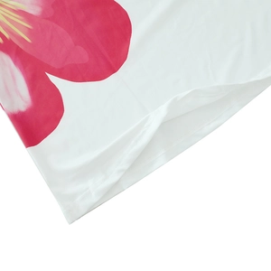 Detail of red floral print on white dress fabric with clean double-needle hem stitching