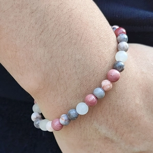 Natural rhodochrosite beaded bracelet with pink and grey stones worn on a wrist