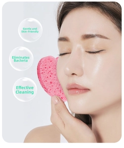 Pink heart-shaped cellulose sponge texture close-up for gentle facial cleansing