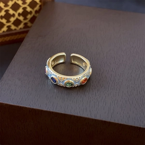 Detailed macro view of an enamel gold open ring with colorful gemstones and S925 hallmark