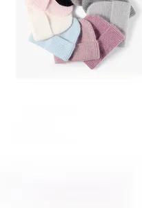 Pile de bonnets en maille douce en diverses couleurs comme rose, beige, bleu et gris