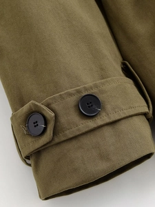 Dettaglio della manica in twill verde militare con bottone nero e cinturino regolabile