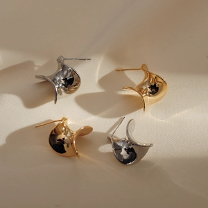 Minimalist spiral geometric earrings in gold and silver finish on silk background