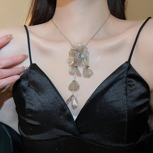 Detailed view of silver flower fringe necklace with champagne petals on a model