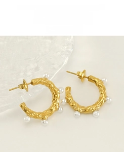 Détail de boucles d'oreilles perles en acier inoxydable doré avec texture martelée