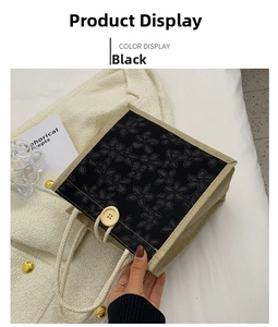 Detail view of black canvas lunch bag with flower patch and round wooden button closure