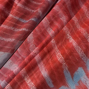 Détail du tissu en maille rouge avec motifs de rayures abstraites bleues et blanches