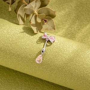 Titanium steel navel ring featuring a pink crystal bow and teardrop gemstone pendant