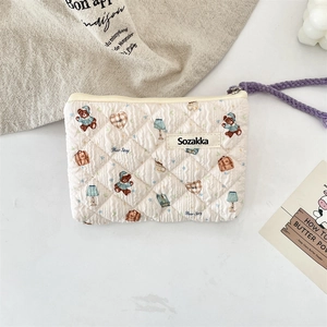 Close-up of quilted floral cosmetic bag with cute cartoon bears and purple wrist strap