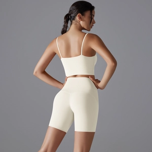 Vista posteriore di set yoga con pantaloncini a vita alta e reggiseno sportivo crema