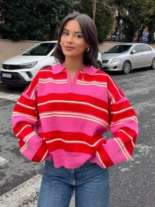 Close-up of pink and red wide stripes on a long-sleeved polo neck knitted sweater