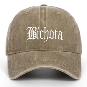 Detailed view of white Gothic Bichota embroidery on a vintage washed olive green baseball cap