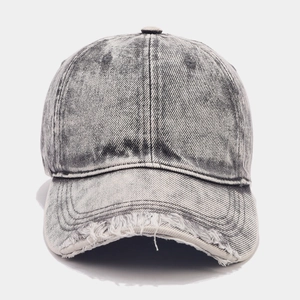 Close-up of distressed grey denim baseball cap featuring vintage ripped hole details