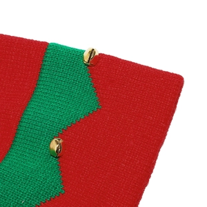 Détail d'une écharpe de Noël en tricot rouge et vert avec de petites cloches dorées