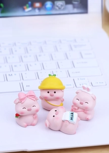 Set of four cute pink resin pig miniatures on laptop keyboard for office desk decor