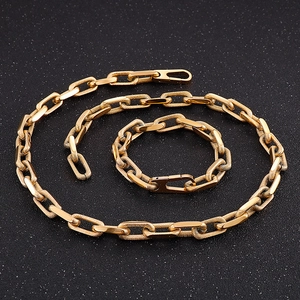 Detailed close-up of textured gold chain necklace and bracelet set with geometric links
