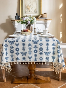 Close-up of vintage blue floral and butterfly print linen tablecloth with tassel trim