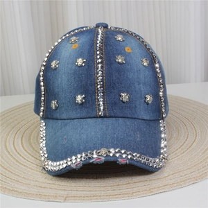 Détail d'une casquette en denim avec rivets métalliques et emblème tête de mort