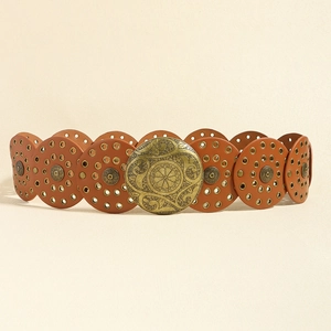 Dettaglio cintura in pelle western con dischi rotondi e fibbia in bronzo con decori floreali