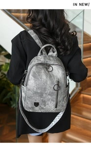 Vintage grey women's backpack with decorative chevron strap in stylish indoor setting