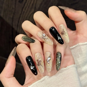 Handmade stiletto press-on nails with black floral, gold glitter, and butterfly designs